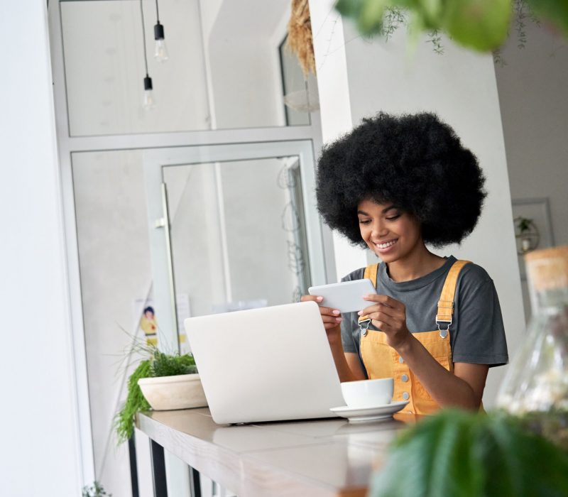 smiling-african-woman-student-watching-mobile-ad-o-524FLZE-scaled.jpg